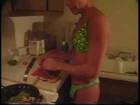 Tanned gay in lingerie prepares dinner in the kitchen while his friend fucks him in the ass
